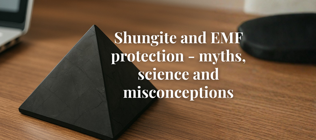 Modern workspace setup with a laptop, phone, and a Shungite pyramid placed nearby